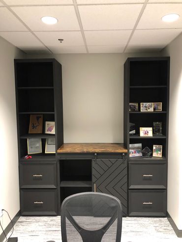 Custom black office built in with a modern look with dark brown counter top.