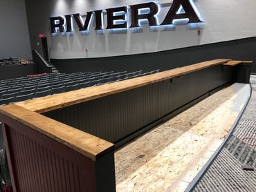 Custom bar seating area in the back of a theater, built by Henry's Legacy Woodworking.
