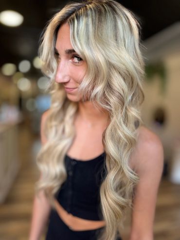 Woman with long wavy blonde hair smiling.