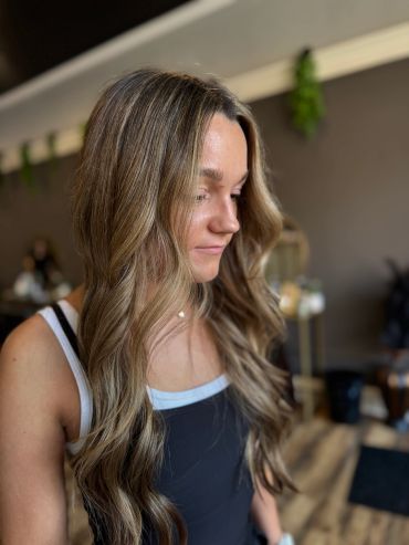 Side profile of a woman with wavy blonde hair.