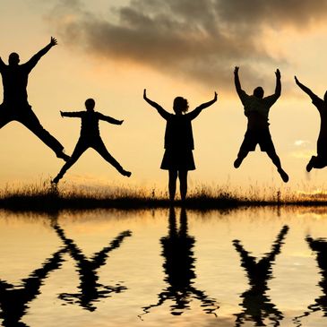 A group of people jumping in the evening sun to represent a range of emotions