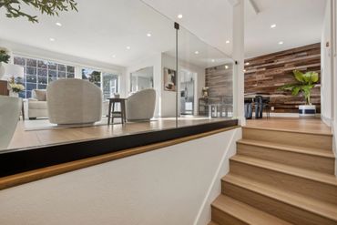 Modern living space with wood accents and glass railing.
