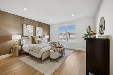 Modern bedroom with beige and white tones, featuring a cozy bed and stylish decor.