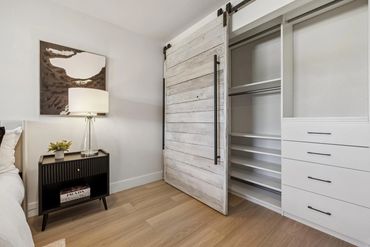Modern bedroom corner with a sliding barn door closet and stylish nightstand.