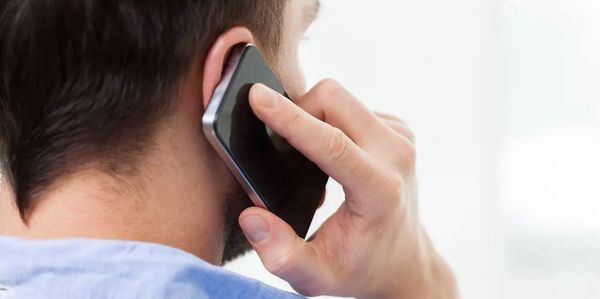 Man holding a smartphone to his ear in a call.