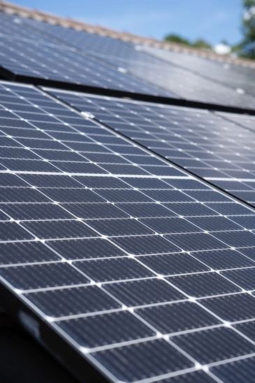 Close-up of solar panels on a roof under clear sky.