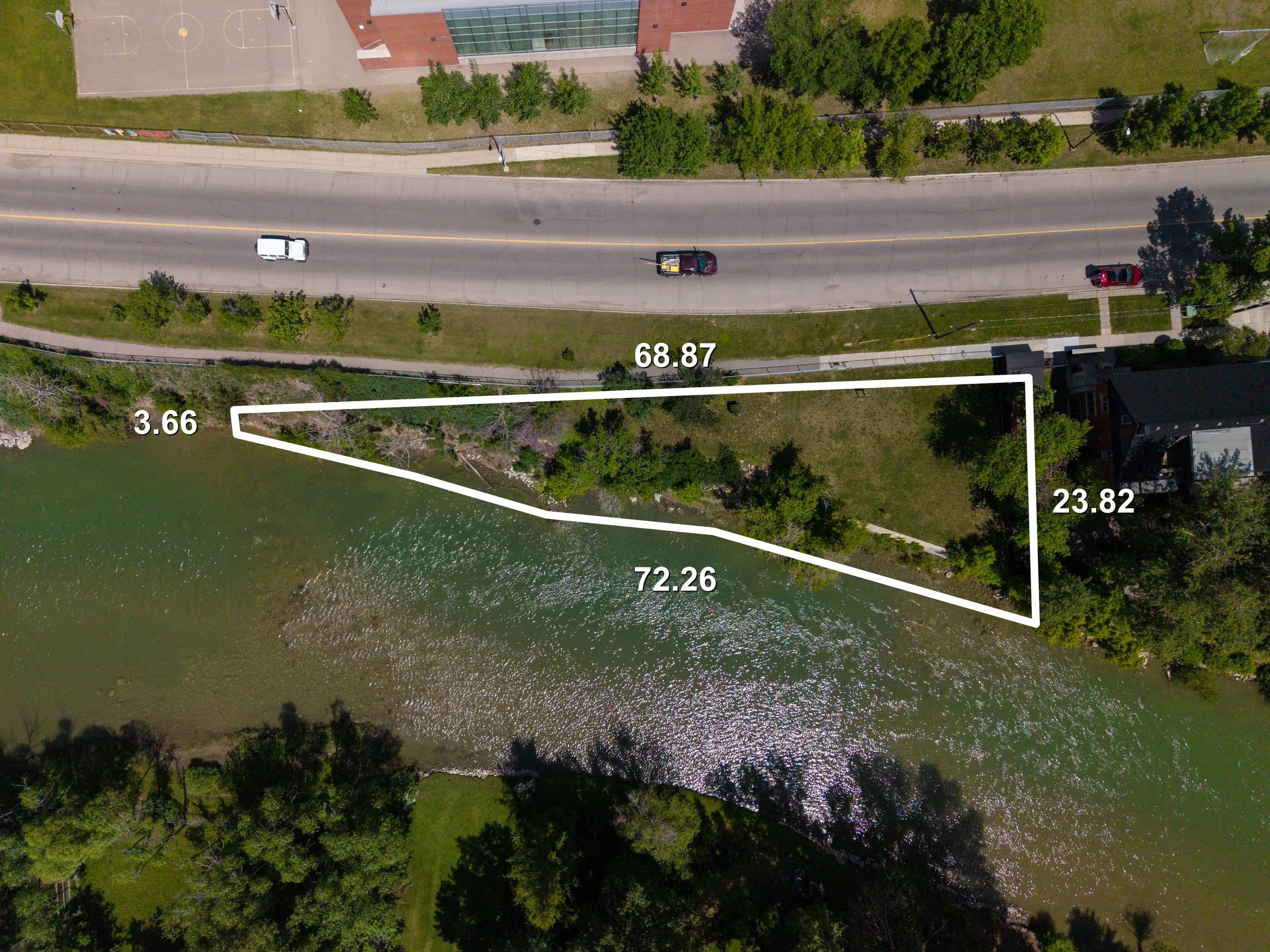 Aerial view of a waterfront property with boundary lines and measurements.