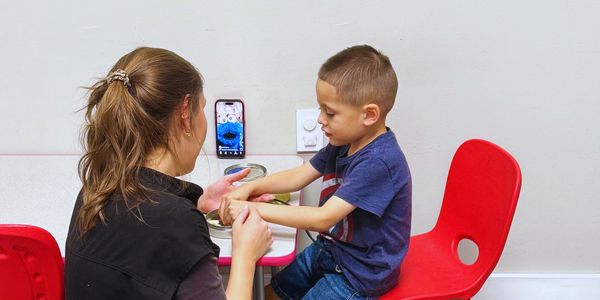 Adult and child engaging in sensory play together.