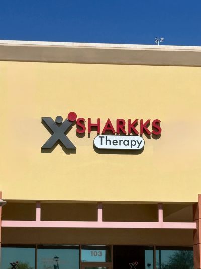 Sign for Sharkks Therapy on a building.
