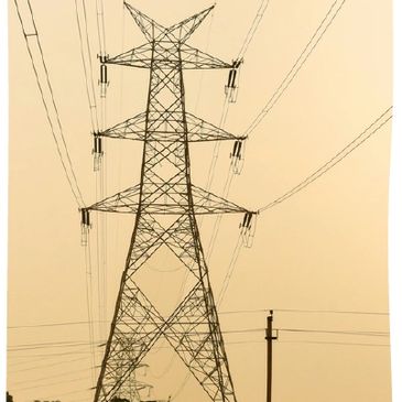 Tall electrical transmission tower with power lines against a muted sky.