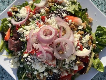 Strawberries, walnuts, feta, & red onion tossed w/ balsamic vinaigrette, mixed greens, & spinach