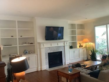 Dark hardwood floors in a living room with built-in bookshelves.