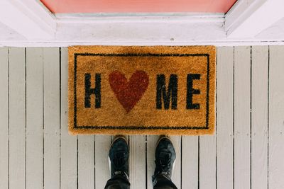 "home" welcome mat with a peach colored door
