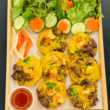 Vietnamese shrimp and beef mini pancakes with fresh vegetables and dipping sauce.