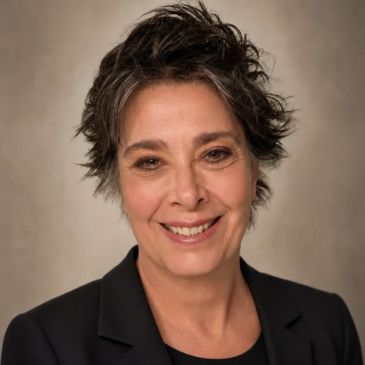 Smiling woman with short spiky hair.