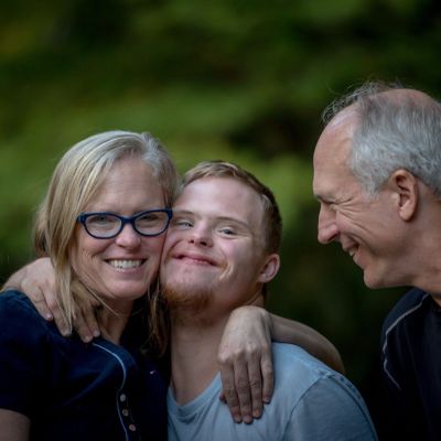 A happy family embraces outdoors with warm smiles and affection.