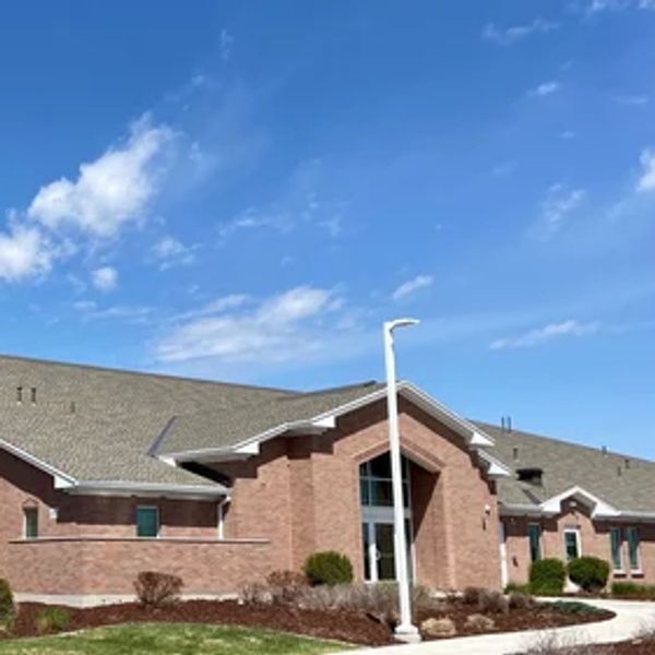 A brick building under a blue sky with white clouds.