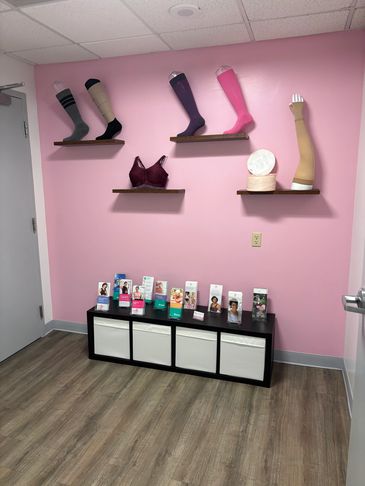 Display of prosthetic limbs and medical supplies in a pink room.