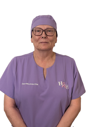 Woman in purple medical scrubs and cap, wearing glasses.