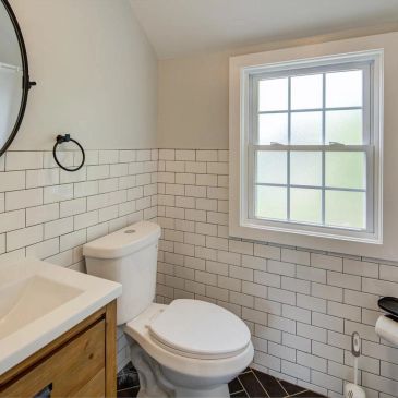 Modern bathroom with white subway tiles and a wooden vanity.