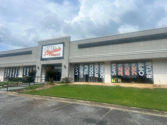 Exterior of 478 Liquidate Discount store with large sale signs in windows.