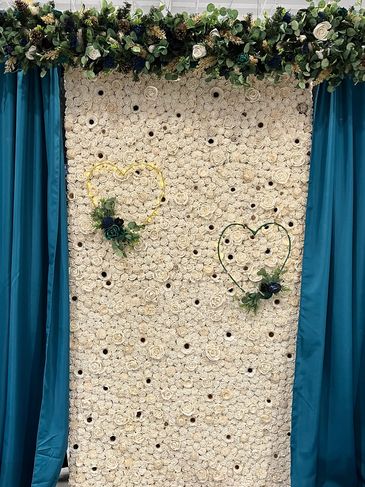 White wood flower wall with teal curtains