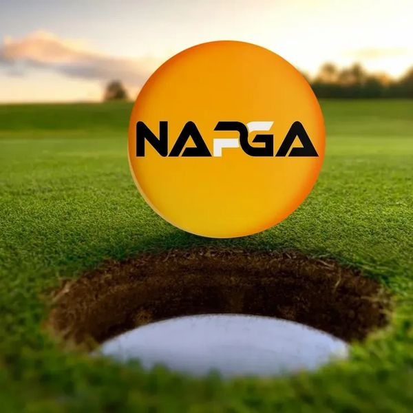 A golf ball with NAPGA logo near a hole on a golf course.