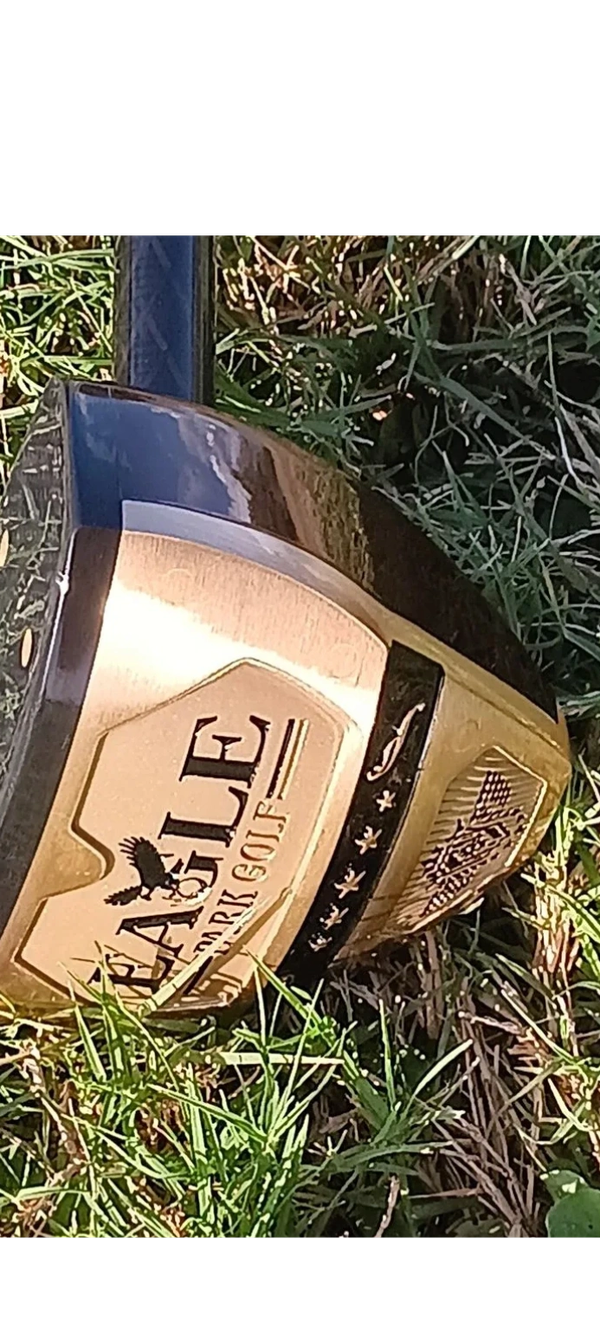 Close-up of an Eagle golf club on green grass outdoors.