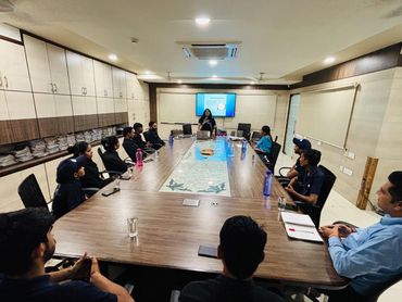 A team meeting in a modern conference room with a presentation on screen.