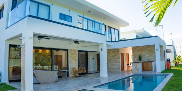 Modern two-story house with glass balconies and a swimming pool.