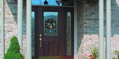 Wood Entry Door with glass inlay, round gray columns brick home