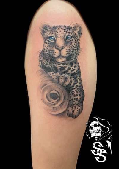 Black and grey tattoo of snow leopard with blue eyes