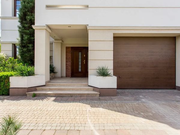 Modern home entrance with wooden door and garage.