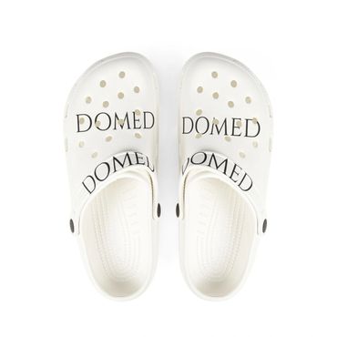White slip-on clogs with black text reading 'DOMED'.
