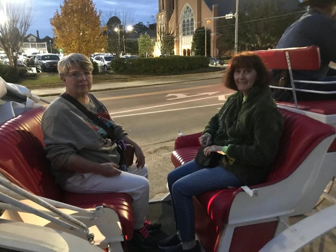 Two sisters seated in a white vis-a-vis