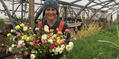 A woman holding a multi-colored flower bouquet
