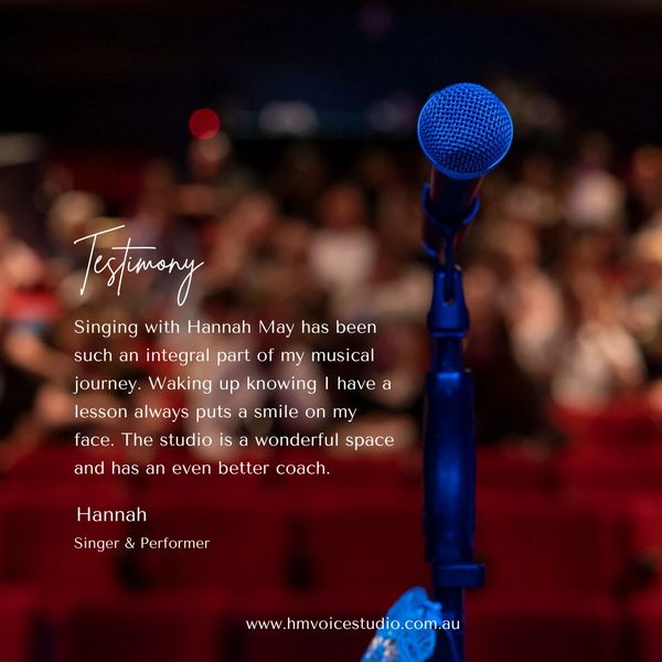 A blue microphone stands out on stage with a testimonial about singing lessons.
