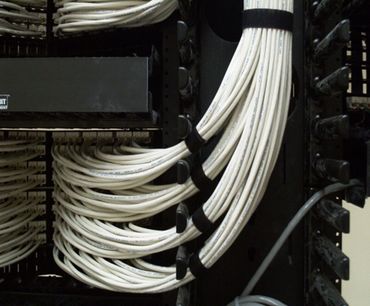 Organized white cables neatly bundled in a server rack.