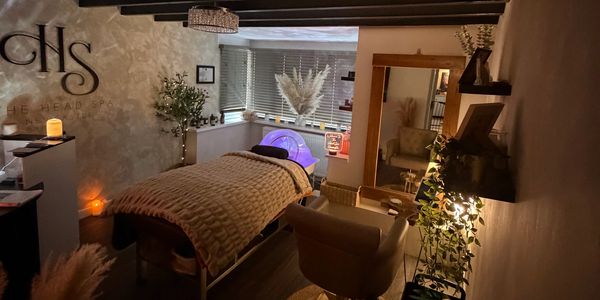Cozy spa room with a massage table and warm lighting.