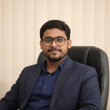 Confident man in glasses and a navy suit sitting in an office chair.