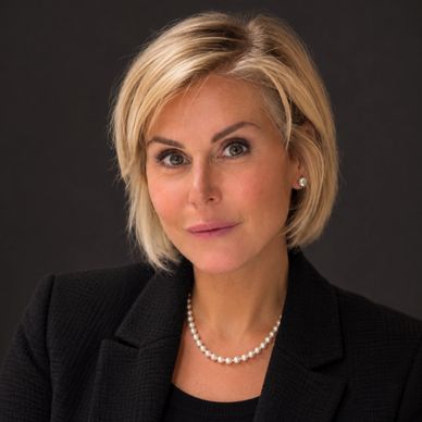 Professional woman with a pearl necklace and black blazer.