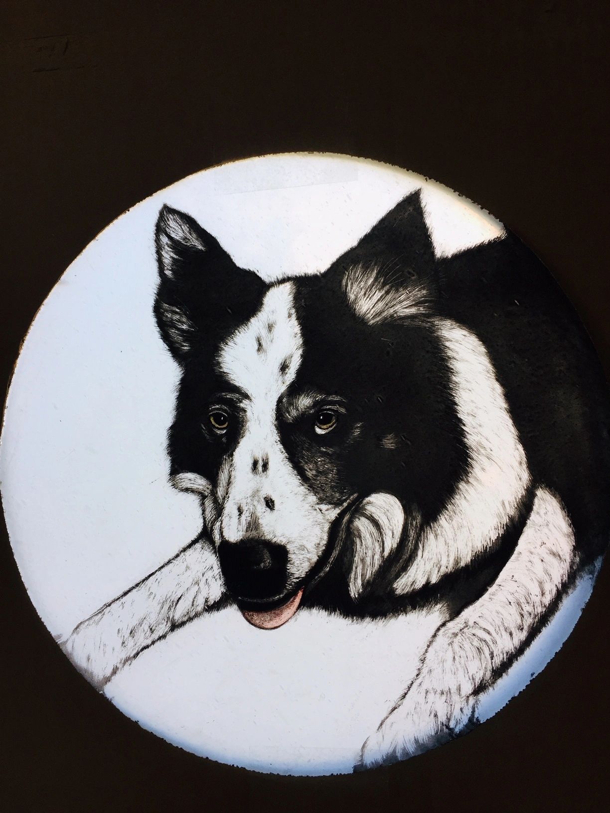 Painted stained glass portrait of a dog with black coat and white collar and forehead and nose