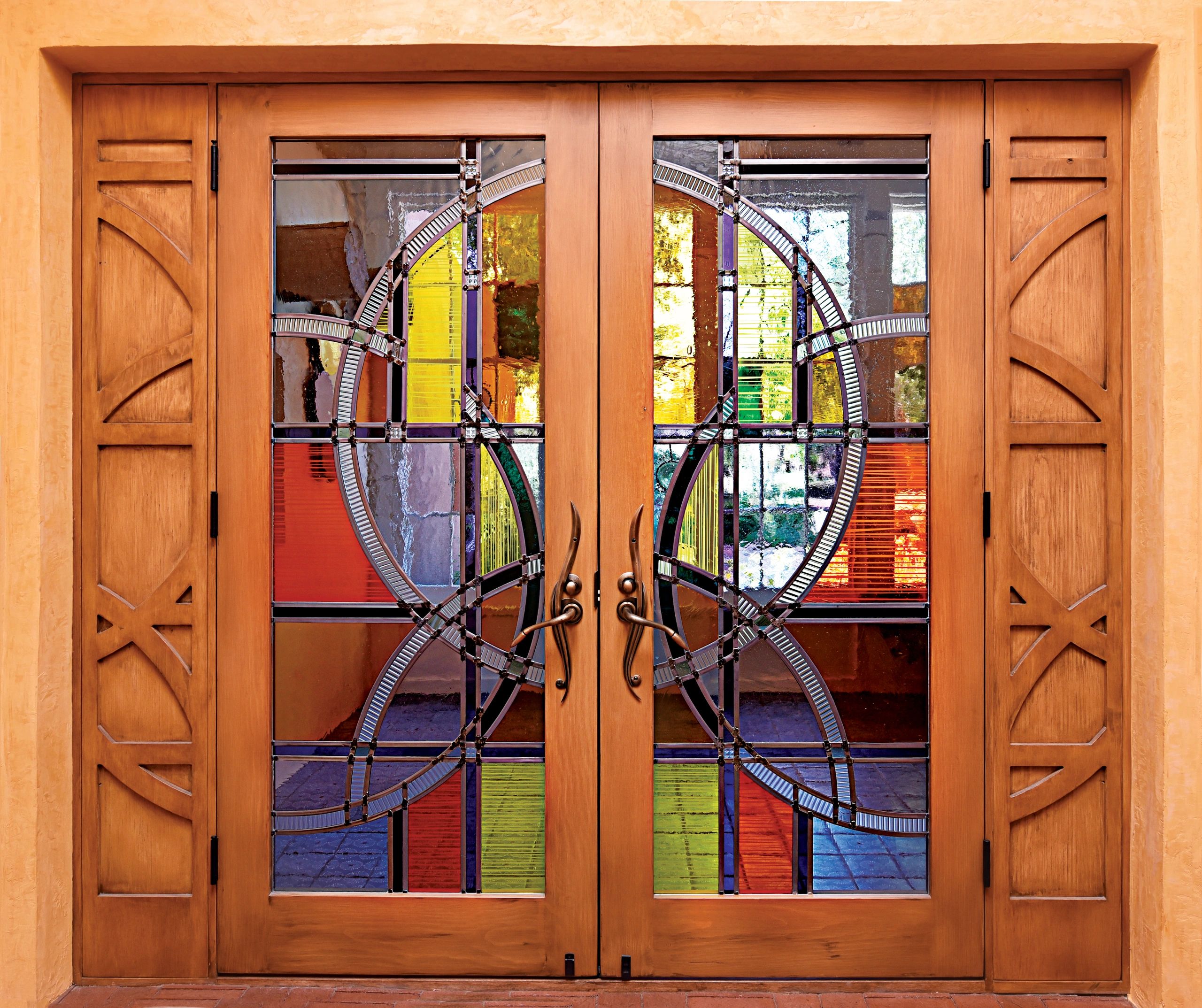 large double door entry with sandblasted yellows, oranges and blue stained glass