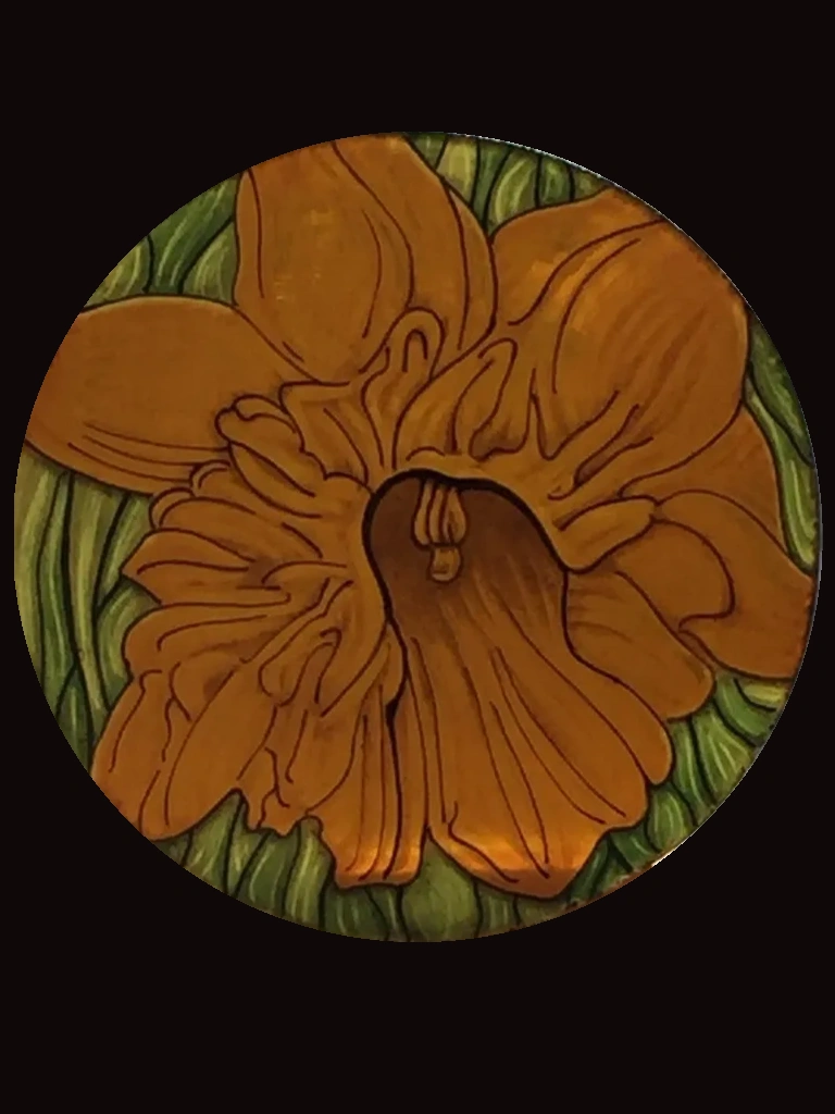 orange and green flower painted on a circle of stained glass