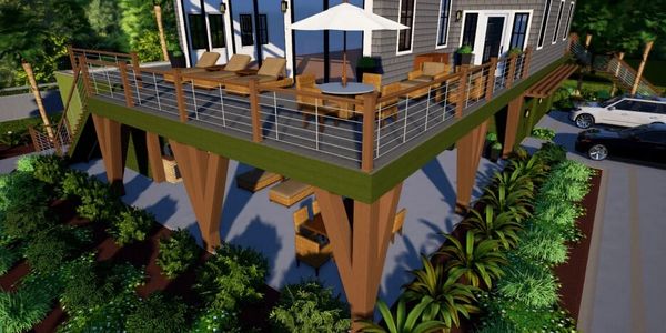 A modern house with a large elevated deck, supported by angled wooden beams, surrounded by lush gree