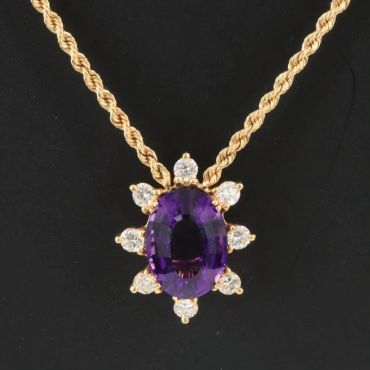 Gold necklace with purple gemstone and diamonds pendant.