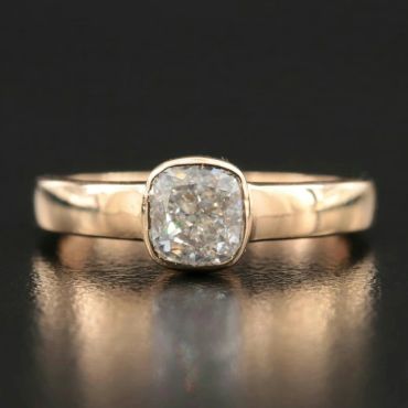 Elegant gold ring with a cushion-cut diamond.
