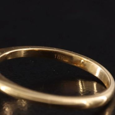 Elegant gold ring with a large gemstone and diamond accents.
