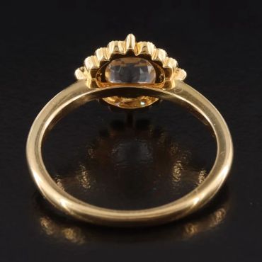 Gold ring with a dark gemstone centerpiece.