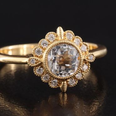 Elegant gold ring with a central diamond and surrounding smaller diamonds.